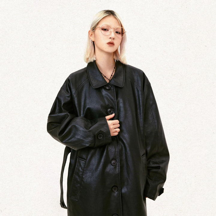 Model wearing the black Y2k Solid Color Leather Coat in a gray background 
