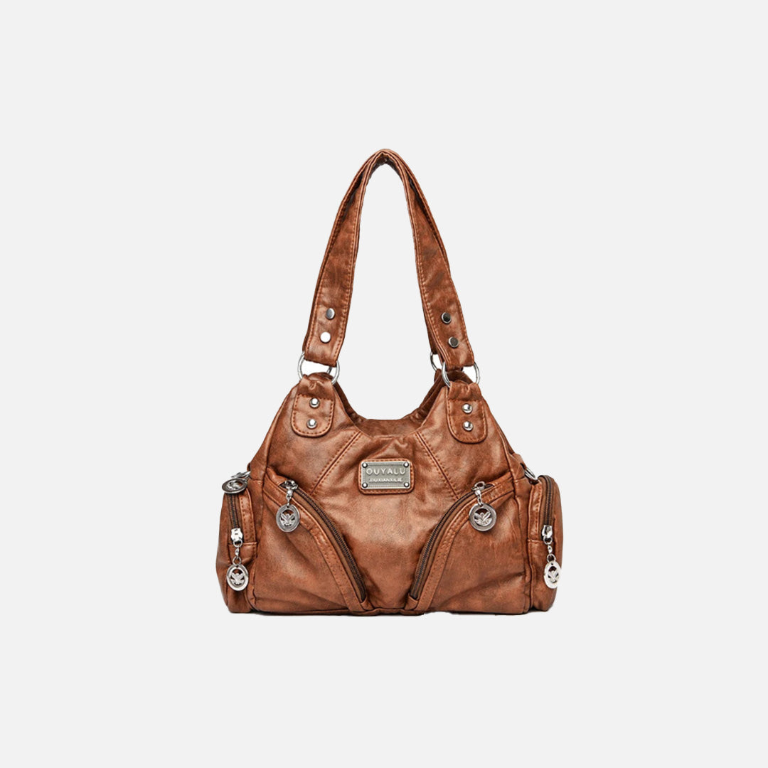 Front view of the light brown Utility Wanderer Handbag in a gray background