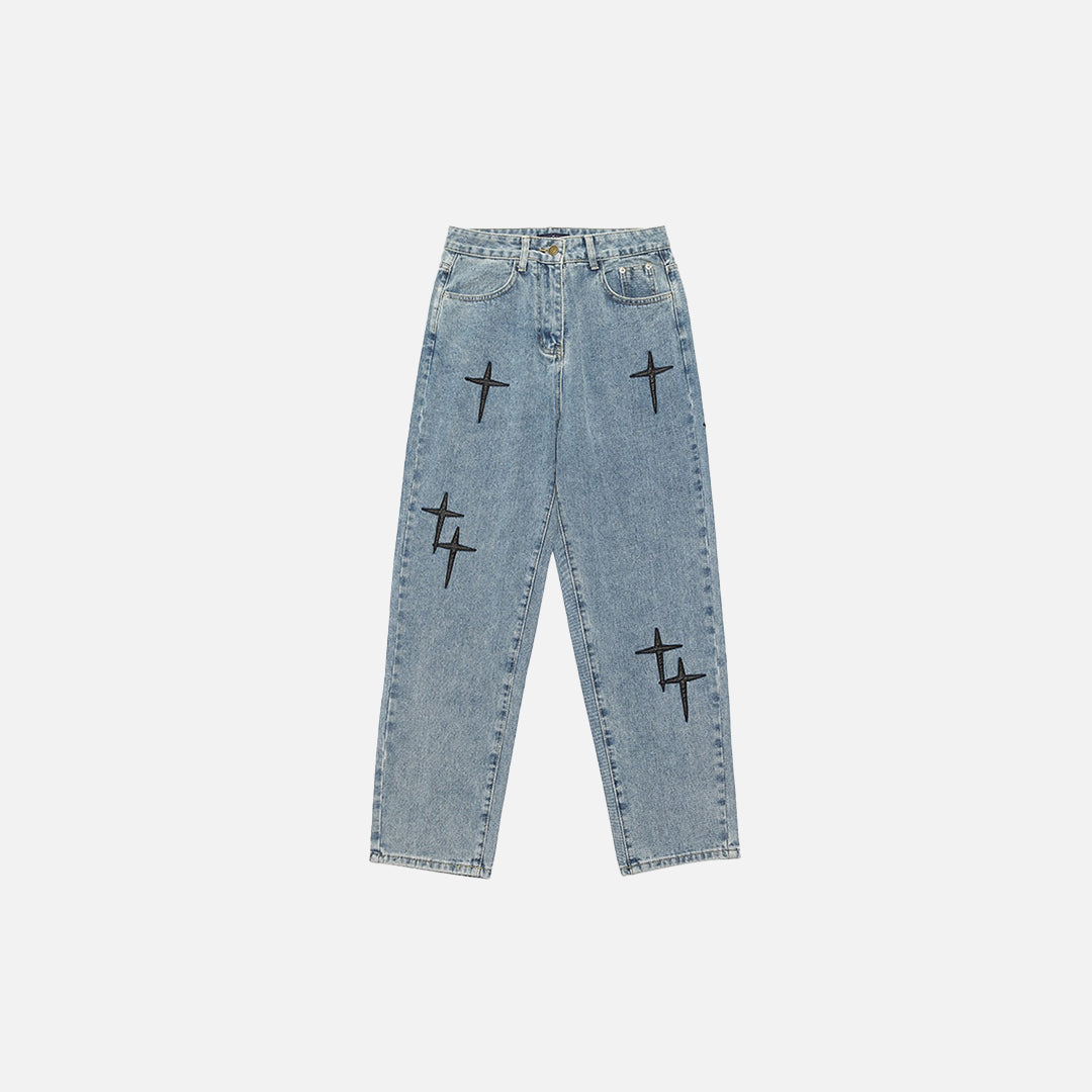 Light blue wide-fit jeans with black cross designs, stylish, plain white background.