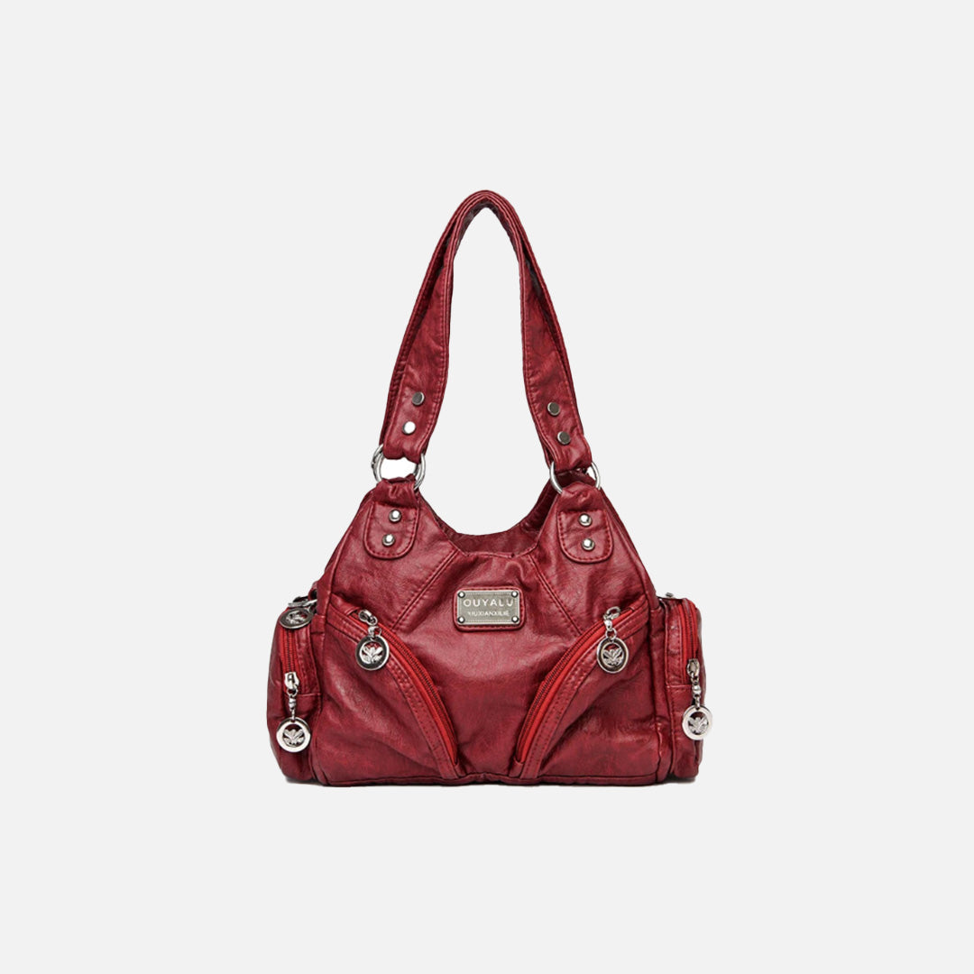 Front view of the burgundy Utility Wanderer Handbag in a gray background