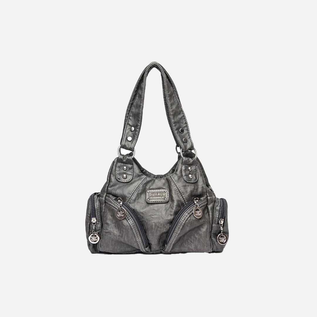 Front view of the light gray Utility Wanderer Handbag in a gray background