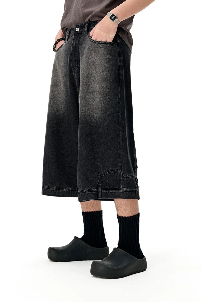 Model wearng the black Washed Denim Pants in a gray background