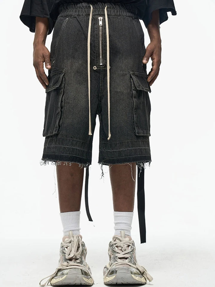 A model wearing the black Zip-Up Loose Washed Pocket Jorts in a gray background