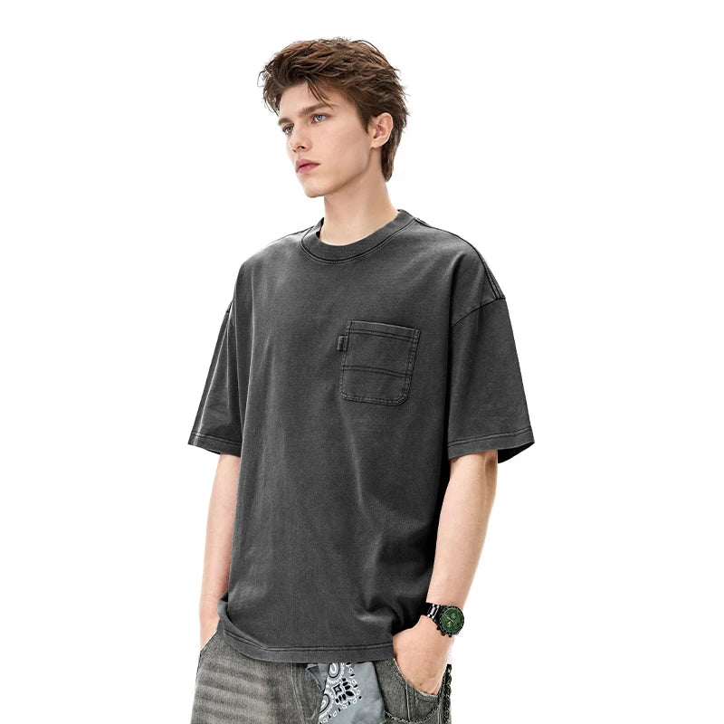 Model wearing the black Classic Catchall T-Shirt in a gray background