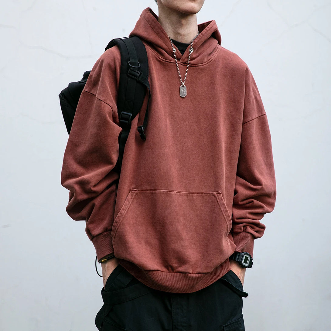 Model wearing the brown Shadow Vibe Hoodie in a gray background