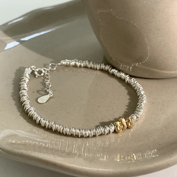 Pulsera ajustable de hilo dorado con cuentas geométricas