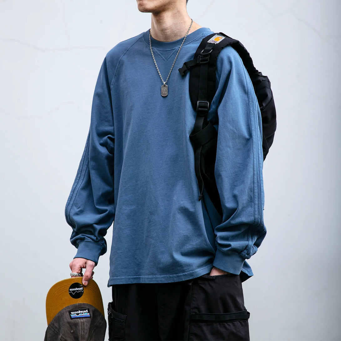 Model wearing the blue Classic Comfort Long Sleeve T-shirt in a gray background