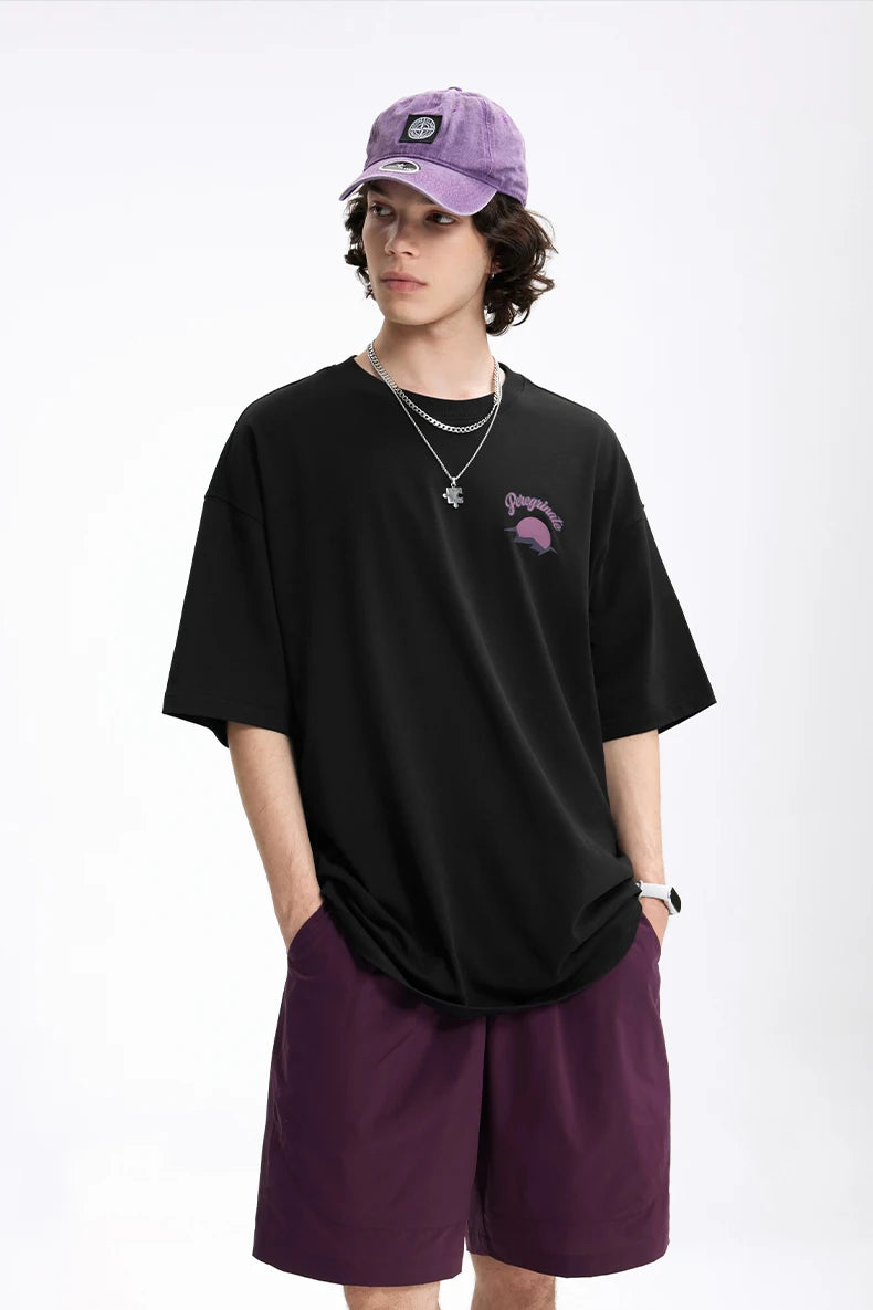 Model wearing the black Epic Voyage T-Shirt in a gray background