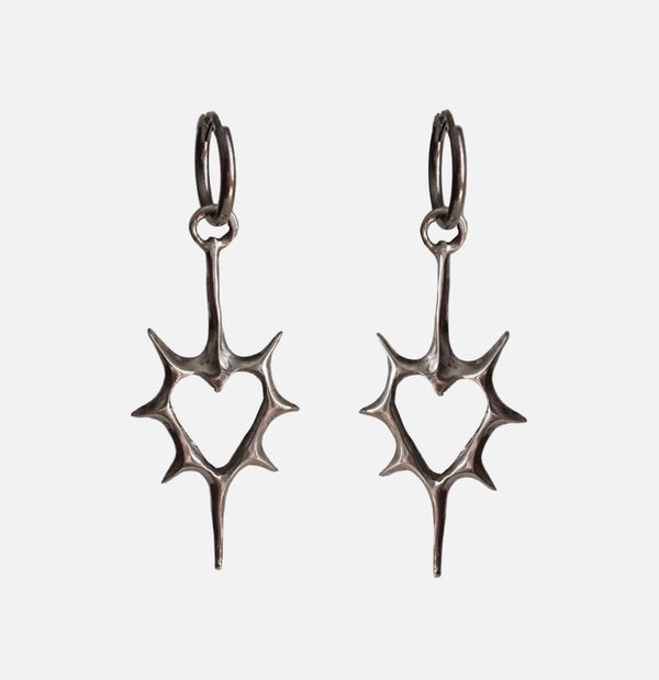Front view of the heart Stellar Edge Earrings in a gray background