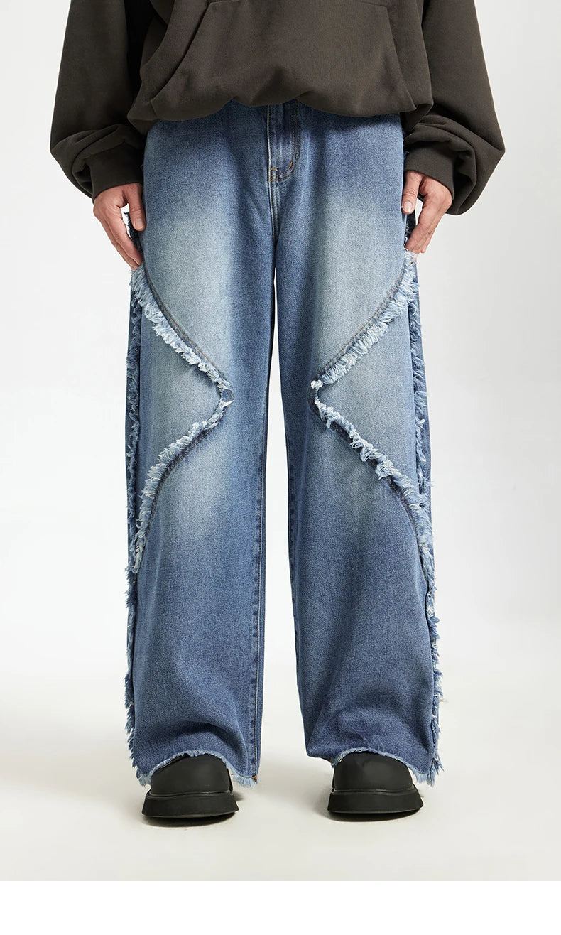 Model wearing the blue Frayed Flow Jeans in a gray background