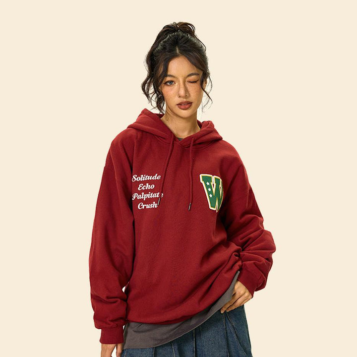 Model wearing the red Oversized Loose Sports Hoodie in a gray background 