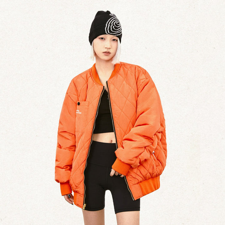 Model wearing the orange Double-sided Loose Classic Jacket  in a gray background 
