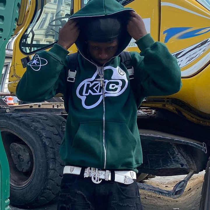 A boy posing while wearing the green Y2K Loose Hoodie as he holding the hoodie