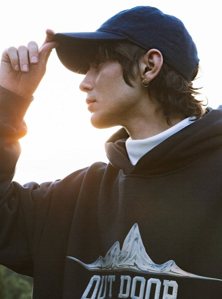 A guy wearing a blue cap and a black Outdoor Hoodie