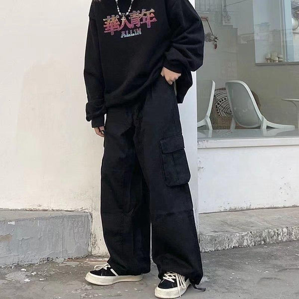 a model posing in the streets while wearing the black Baggy Vintage Cargo Pants