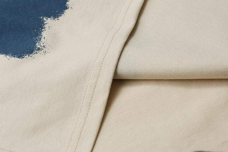 Beige T-shirt with soft fabric, blue splashes, precise stitching, streetwear design