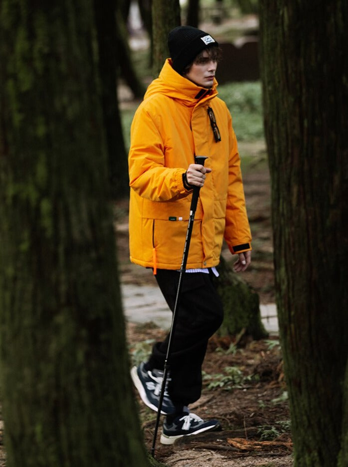 A guy in the forest wearing orange rain captain jacket