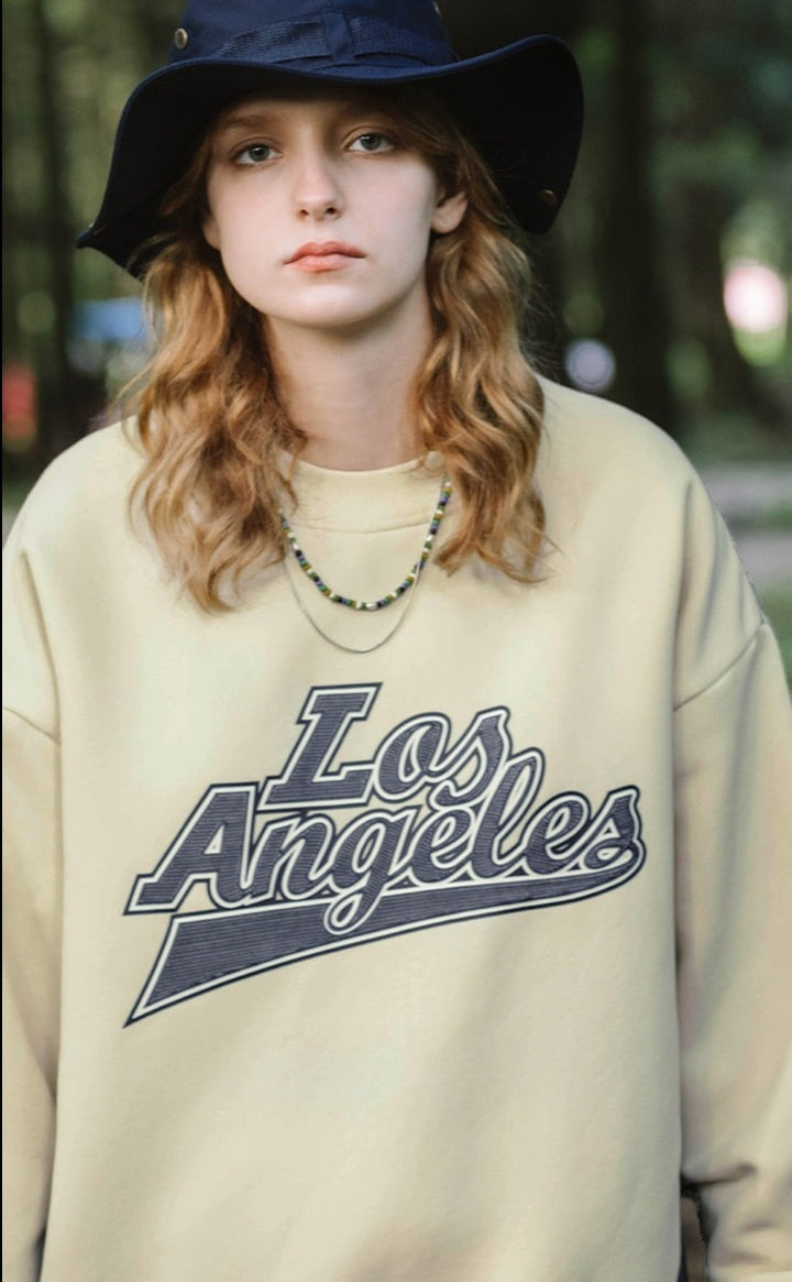A girl wearing apricot Los Angeles Sweatshirt