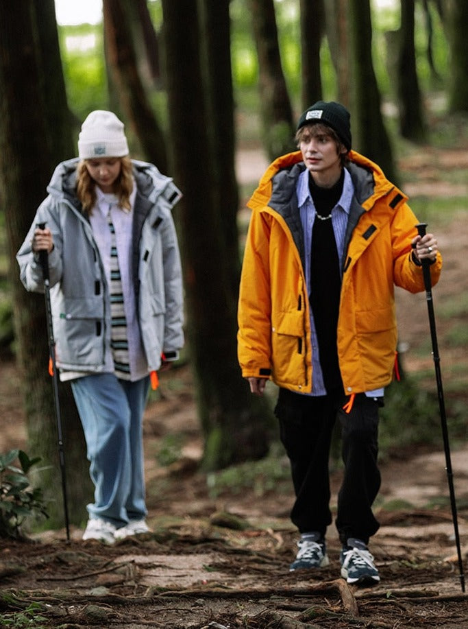 A guy and a girl wearing rain captain jacket in the forest