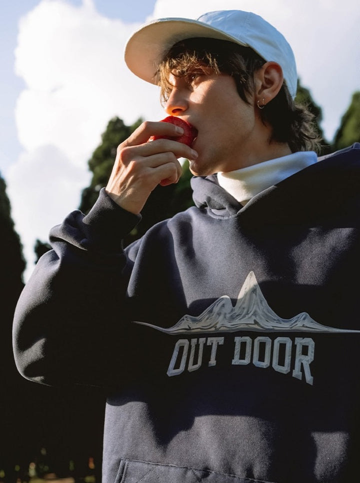 A guy eating an apple and wearing Outdoor Hoodie