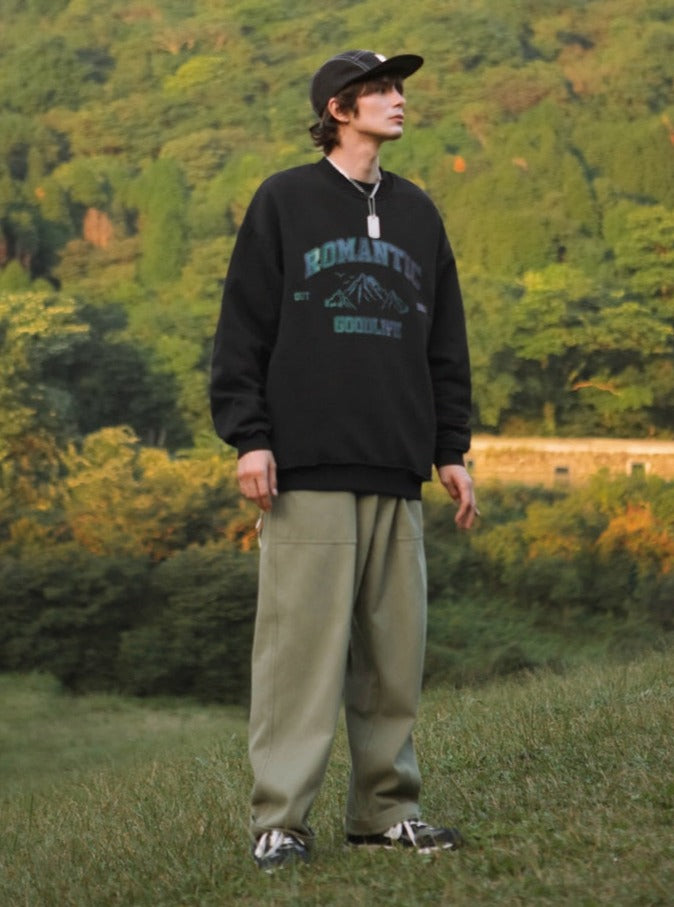 A guy in the field wearing black good life sweatshirt