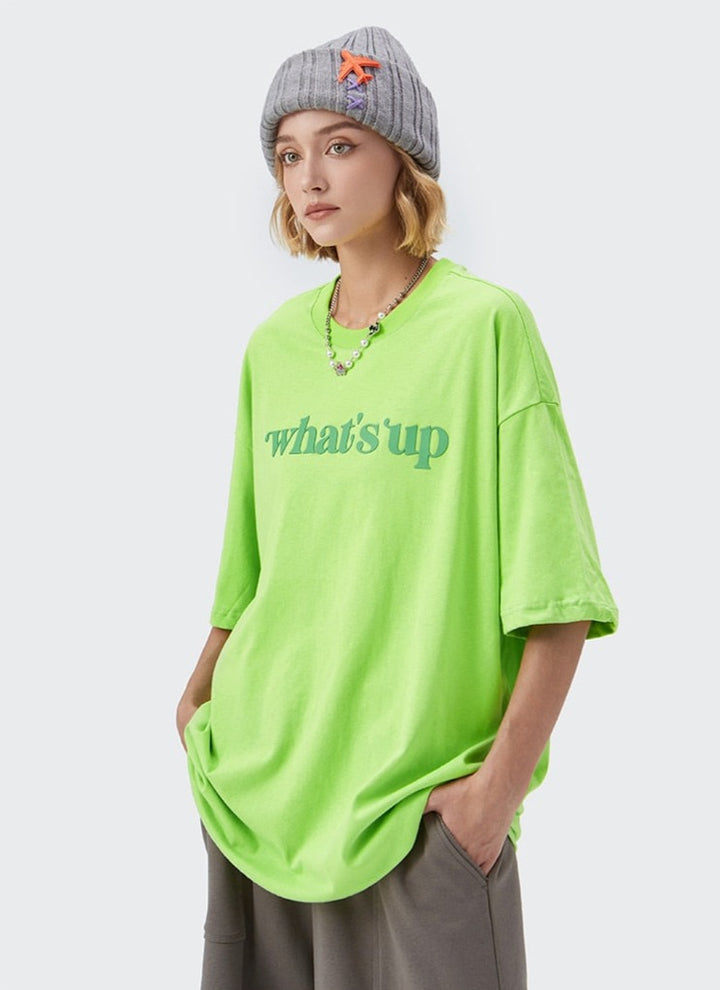 A girl wearing green what's up T-shirt